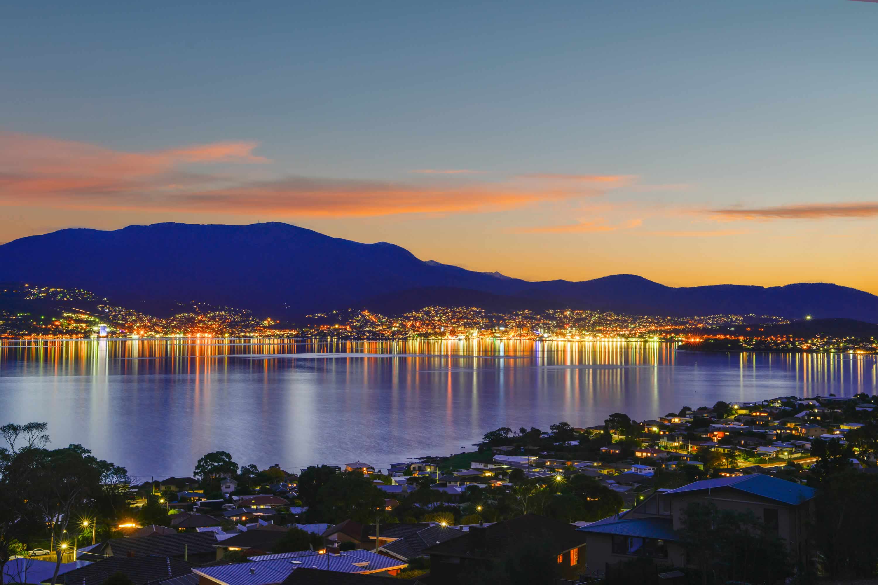 View looking across the River Derwent towards Hobart at night, with reflection of city lights on the water. Photo: Owen Fielding.